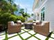 Charming outdoor patio with woven chairs surrounding a cozy fire pit, perfect for relaxing and entertaining in style at 3516 Casey Key Rd, Nokomis, FL 34275