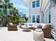 Inviting outdoor patio featuring a comfortable seating area, complemented by lush palm trees and serene surroundings at 3516 Casey Key Rd, Nokomis, FL 34275