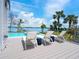 Relax on this spacious pool deck featuring modern lounge chairs and offering stunning waterfront views at 3516 Casey Key Rd, Nokomis, FL 34275