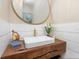 Chic powder room featuring a unique wood countertop, vessel sink, round mirror, and stylish decor at 3516 Casey Key Rd, Nokomis, FL 34275