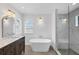 Bright bathroom featuring a soaking tub, a shower, a window and a vanity with double sinks at 381 La Playa Ln, Port Charlotte, FL 33953
