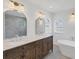 Bright bathroom with double sink vanity, large mirrors, soaking tub and tiled shower at 381 La Playa Ln, Port Charlotte, FL 33953