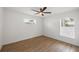 Bedroom featuring two windows, ceiling fan, and wood-look flooring at 381 La Playa Ln, Port Charlotte, FL 33953