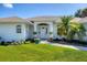 The front entrance features a well-kept lawn with manicured flower beds and a covered entrance leading to a white front door at 381 La Playa Ln, Port Charlotte, FL 33953