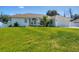 Charming single-story home featuring a manicured lawn and a pristine driveway leading to an attached two-car garage at 381 La Playa Ln, Port Charlotte, FL 33953