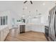 Modern white kitchen showcasing stainless appliances, quartz counters, wood look flooring and lots of natural light at 381 La Playa Ln, Port Charlotte, FL 33953