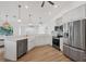 White kitchen boasts stainless appliances, undermount sink, wood look flooring, recessed lights, and an open concept at 381 La Playa Ln, Port Charlotte, FL 33953
