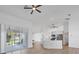 An open floor plan connects the living room and kitchen, with a large glass slider and modern appliances at 381 La Playa Ln, Port Charlotte, FL 33953