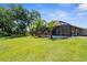 Spacious backyard with lush lawn, tropical landscaping, and a screened-in pool area for outdoor enjoyment at 3950 Pepper Ln, North Port, FL 34287