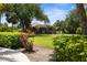 Green backyard features a screened-in lanai and pool area, surrounded by lush landscaping at 3950 Pepper Ln, North Port, FL 34287