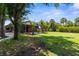 Large backyard with lush green lawn, mature trees, and screened-in pool area for outdoor enjoyment at 3950 Pepper Ln, North Port, FL 34287