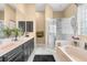 Elegant bathroom with double vanity, soaking tub, glass-enclosed shower, and neutral decor at 3950 Pepper Ln, North Port, FL 34287