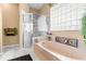Relaxing bathroom featuring an oval tub, shower, and window at 3950 Pepper Ln, North Port, FL 34287