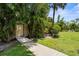 Sidewalk access to detached storage, with tropical landscaping around the building at 3950 Pepper Ln, North Port, FL 34287