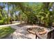 Outdoor fire pit surrounded by lush tropical landscaping, offering a relaxing space at 3950 Pepper Ln, North Port, FL 34287