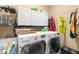 Laundry room with front load washer and dryer, storage cabinets, and clothes rod at 3950 Pepper Ln, North Port, FL 34287