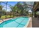 Screened-in pool and spa area with lush tropical landscaping, perfect for relaxing and entertaining at 3950 Pepper Ln, North Port, FL 34287