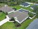 Aerial view of a single-story home showing a screened-in pool, lush lawn, and a two-car garage at 4103 Kinlock St, North Port, FL 34286