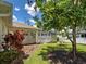 Landscaped backyard with a screened-in lanai, a garden bed, and a lush lawn at 4103 Kinlock St, North Port, FL 34286