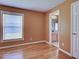 Bright bedroom with wood floors, a window with blinds, and a doorway to bathroom at 4103 Kinlock St, North Port, FL 34286
