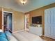 This staged bedroom features neutral paint, wood floors and a white dresser with a mounted television at 4103 Kinlock St, North Port, FL 34286