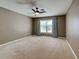 Bedroom with a ceiling fan, neutral walls, and a window with blue curtains, creating a relaxing atmosphere at 4103 Kinlock St, North Port, FL 34286