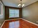 Traditional dining room featuring hardwood floors, a classic chandelier, and a large window offering natural light at 4103 Kinlock St, North Port, FL 34286