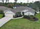 Charming single-story home boasts a lush lawn, landscaped beds, and an attached two-car garage at 4103 Kinlock St, North Port, FL 34286