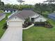 Aerial view of home featuring lush landscaping, a well-maintained lawn, and an attached two-car garage at 4103 Kinlock St, North Port, FL 34286