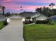 Charming home featuring a lush green lawn, well-manicured landscaping and an attached two-car garage at 4103 Kinlock St, North Port, FL 34286
