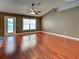 The bright living room includes wood floors, a ceiling fan, and a large window that allows for natural light at 4103 Kinlock St, North Port, FL 34286