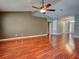 Large living room with hardwood floors, a ceiling fan, and neutral wall colors creating a versatile and airy space at 4103 Kinlock St, North Port, FL 34286