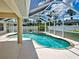 This covered pool with a screened enclosure features a built-in hot tub and a serene backyard view at 4103 Kinlock St, North Port, FL 34286