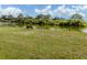 Expansive lawn extends to a tranquil pond, with a bench to enjoy the view at 4192 Tarpon Rd, Venice, FL 34293