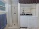 A combined bathroom and laundry area featuring a shower stall and stacked washer/dryer at 4192 Tarpon Rd, Venice, FL 34293