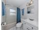 A well-lit bathroom featuring a tub with shower, white vanity, and blue accents at 4192 Tarpon Rd, Venice, FL 34293