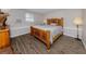 Comfortable bedroom with a wooden bed frame, light-colored walls, and wood-look flooring at 4192 Tarpon Rd, Venice, FL 34293