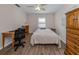 A bright bedroom with wood-look flooring, desk, and ample storage space at 4192 Tarpon Rd, Venice, FL 34293