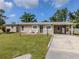 Single-story home featuring a well-maintained lawn, carport, and a small patio with chairs at 4192 Tarpon Rd, Venice, FL 34293