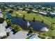 Aerial view of a community with a golf course, pond with a fountain, and lush landscaping at 421 Cerromar Ter # 471, Venice, FL 34293