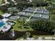 Aerial view of tennis courts, a pool and a pond with fountain in a lush, green community at 421 Cerromar Ter # 471, Venice, FL 34293