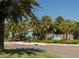 Inviting Venice Beach entrance featuring lush landscaping and swaying palm trees, a picturesque coastal scene at 421 Cerromar Ter # 471, Venice, FL 34293