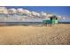 Coastal beach featuring a lifeguard stand under a sunny sky with light clouds, ideal for relaxation and outdoor activities at 421 Cerromar Ter # 471, Venice, FL 34293