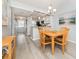 Bright dining area with wood flooring, stylish chandelier, and adjacent kitchen at 421 Cerromar Ter # 471, Venice, FL 34293