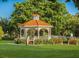 Picturesque gazebo in a lush garden setting, with manicured lawns and inviting benches for relaxation at 421 Cerromar Ter # 471, Venice, FL 34293
