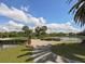 Picturesque view of the golf course with water features, beautiful sky, and mature trees at 421 Cerromar Ter # 471, Venice, FL 34293