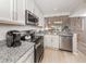 Open concept kitchen with granite countertops and stainless steel appliances at 421 Cerromar Ter # 471, Venice, FL 34293