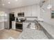 Modern kitchen with granite countertops, stainless appliances, and white cabinets at 421 Cerromar Ter # 471, Venice, FL 34293