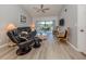Comfortable living room featuring a ceiling fan, plush seating, and a screened balcony view at 421 Cerromar Ter # 471, Venice, FL 34293