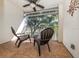 This screened-in porch features 2 chairs and overlooks a natural landscape for peaceful outdoor living at 421 Cerromar Ter # 471, Venice, FL 34293